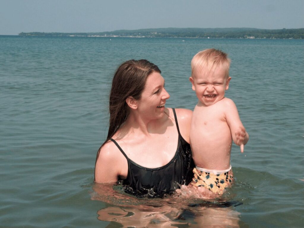 Mom holding small boy in Lake Michigan- family friendly outdoor activities in Petoskey, Michigan