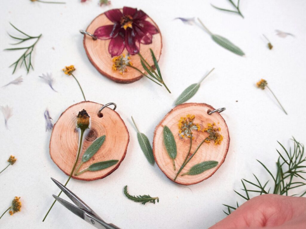 nature craft: small wood slices with pressed flowers for necklace-making. 