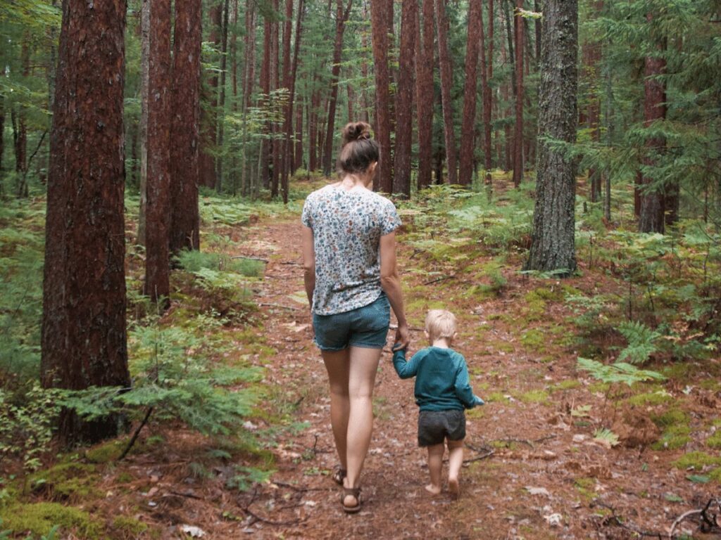 Mom and small boy walking on path in woods- summer bucket list