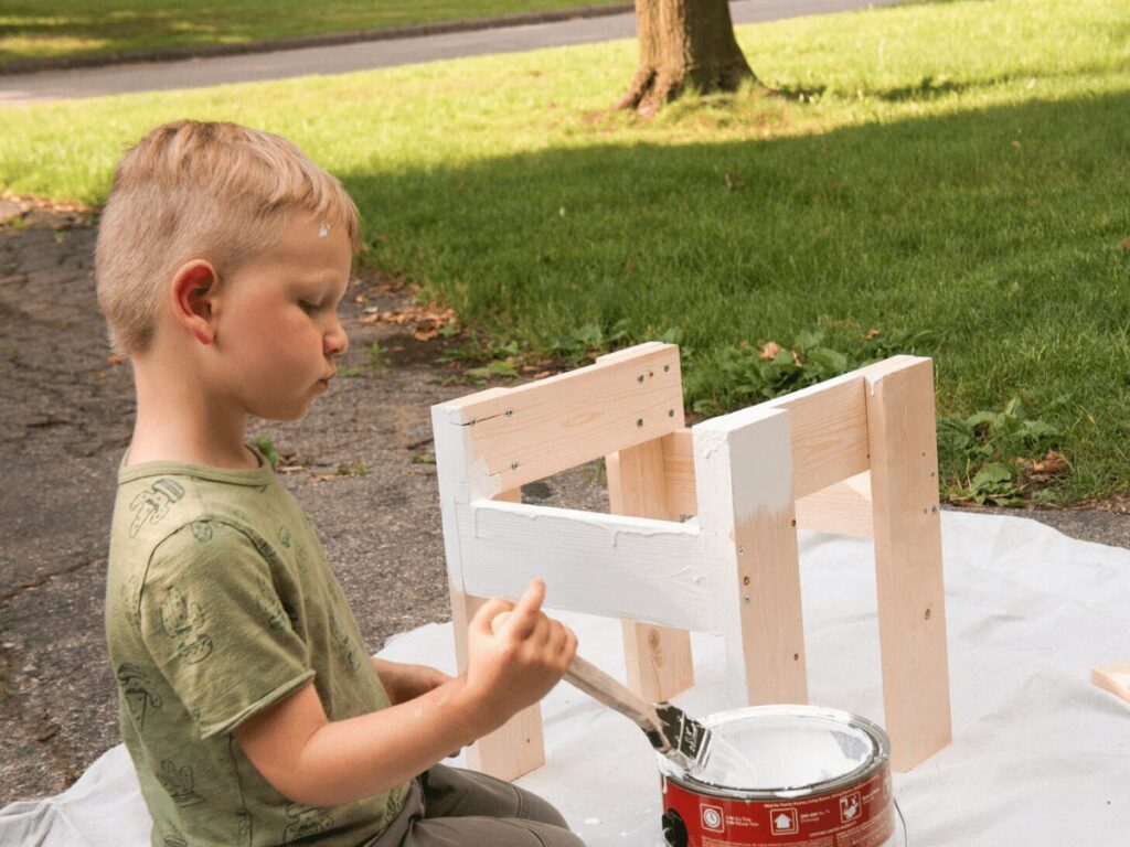 small boy paints table he's building- business ideas for kids