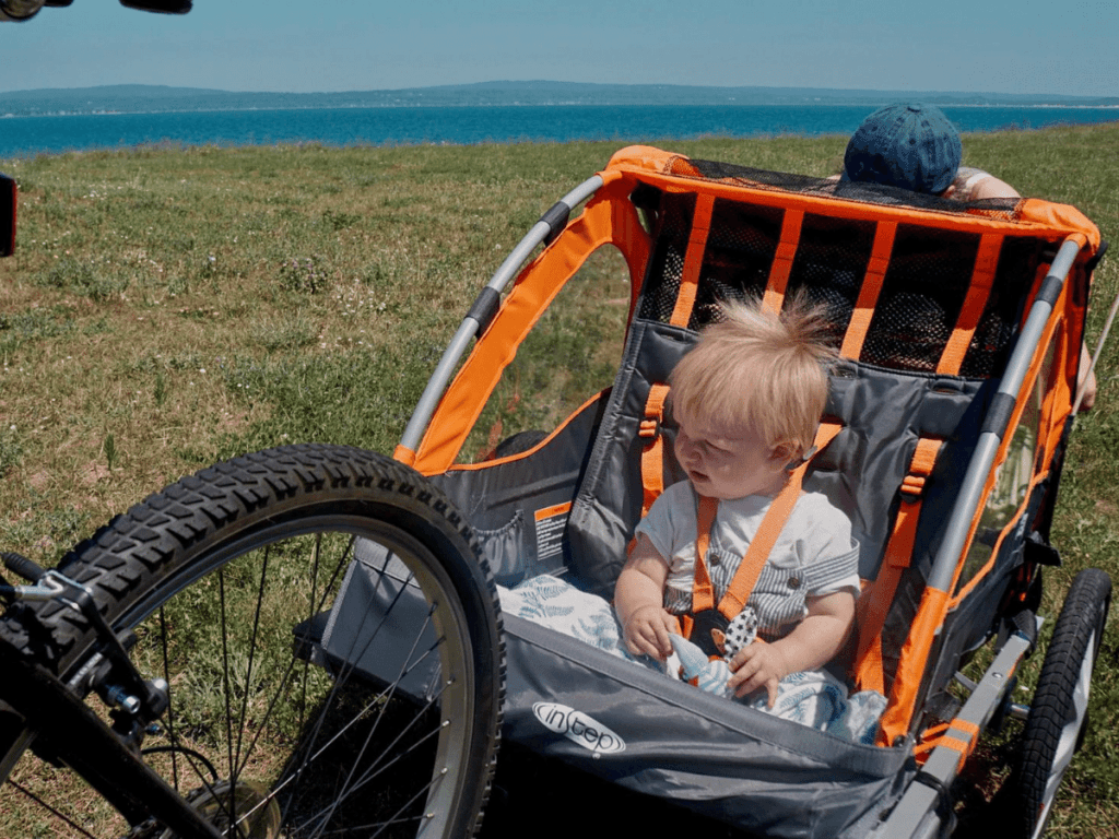 small boy sitting in bike trailer- outdoor gear for babies