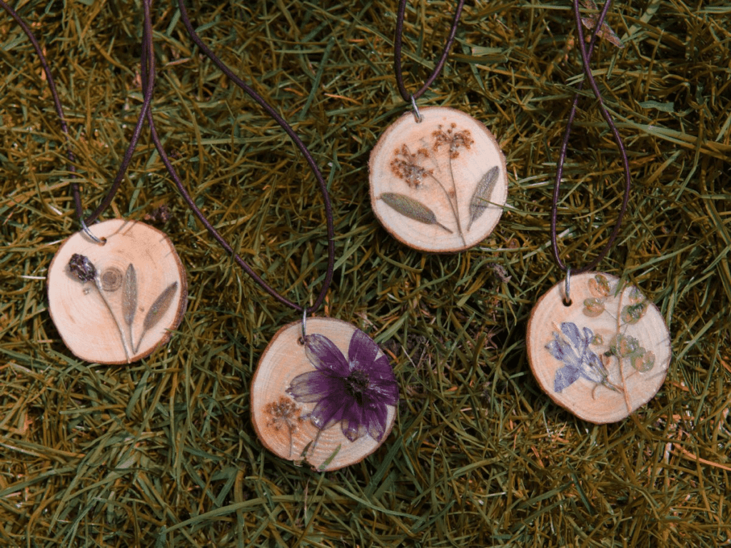 close up of wood slice necklaces with pressed flowers- flower crafts