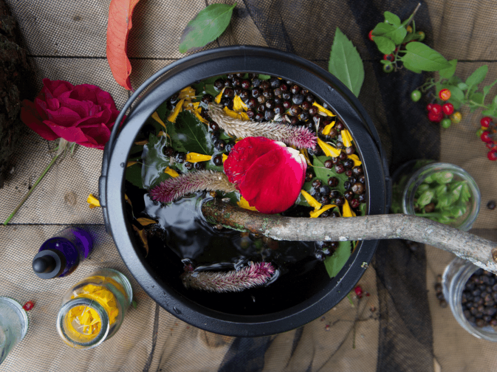 halloween activities for kids, close up of cauldron filled with flower petals, berries, and leaves