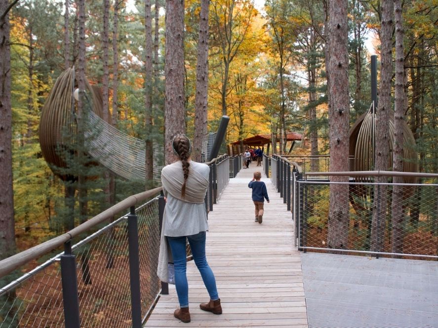 mom and boy walking on canopy walk at dow gardens