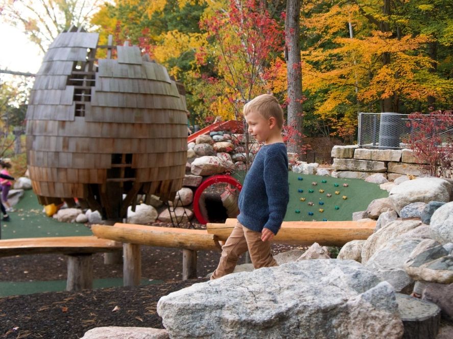 small boy balancing on boulders at dow gardens playground