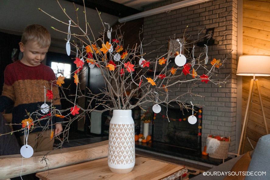 several branches in a vase decorated with leaves as a thankful tree