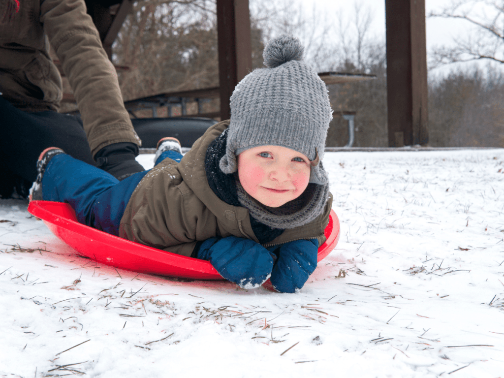 small boy laying on sled