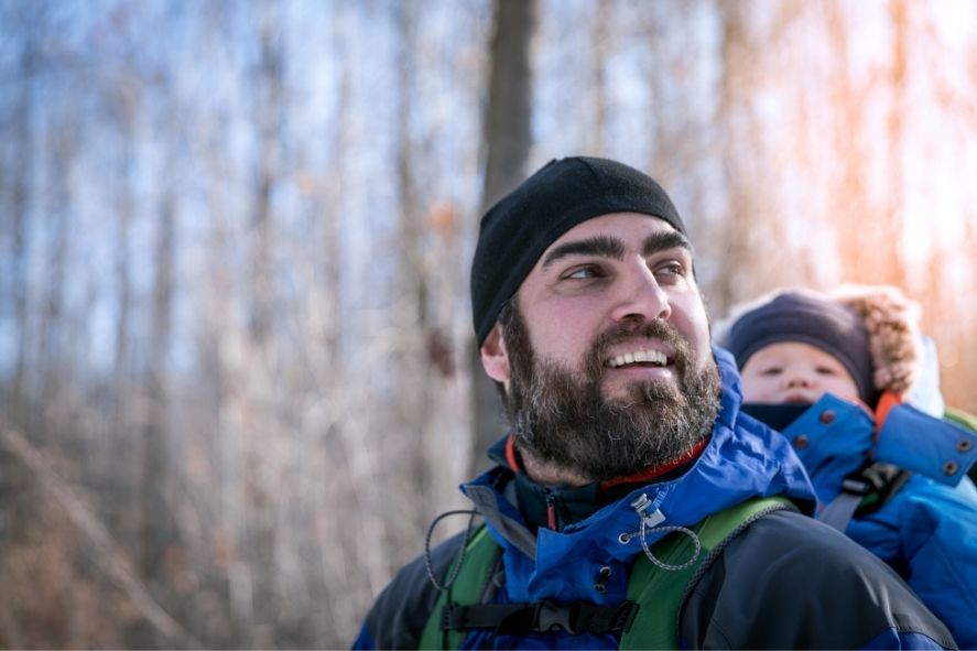 Father carrying baby on his back while hiking