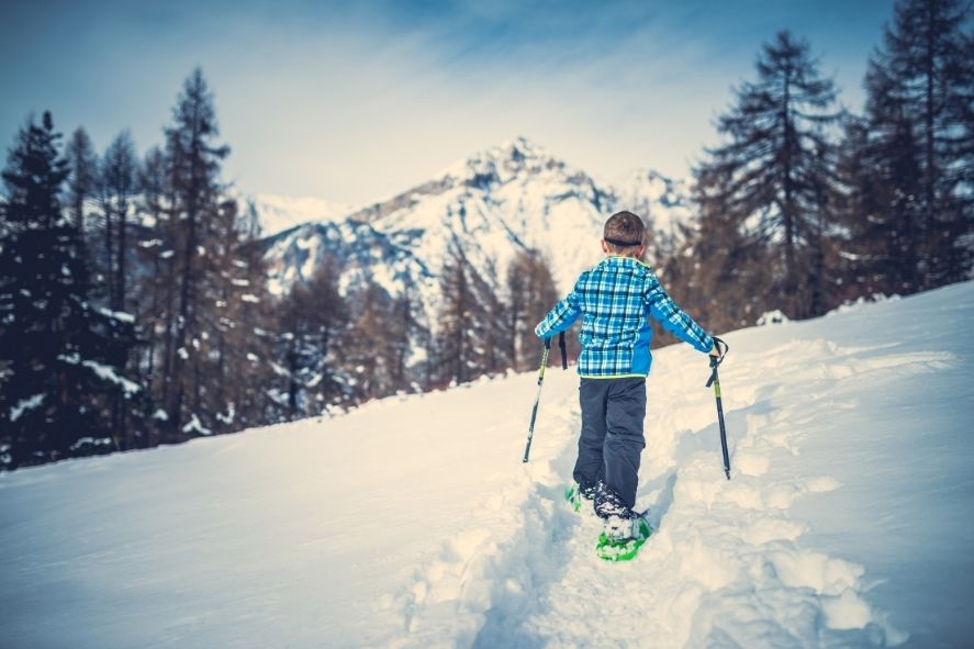 boy snowshoeing on a trail