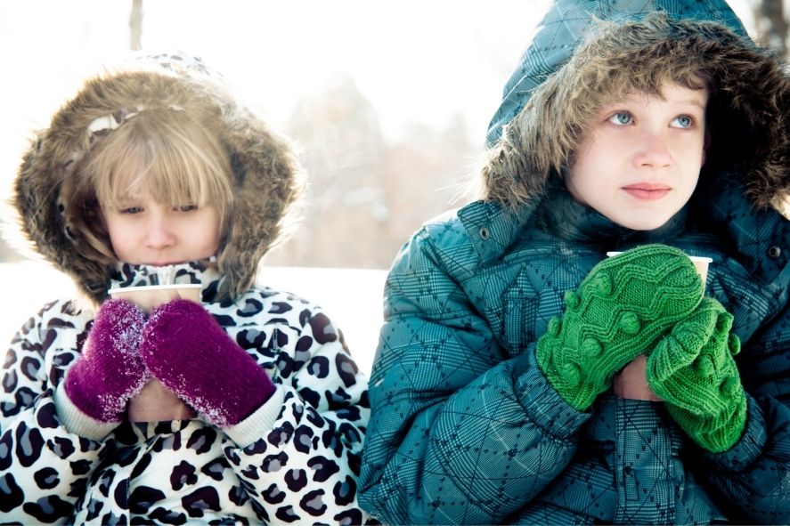 kids sipping hot drinks outside in snow