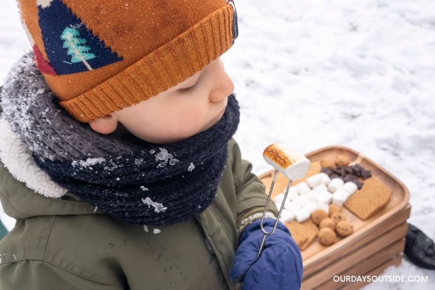 boy holding up roasted marshmallow
