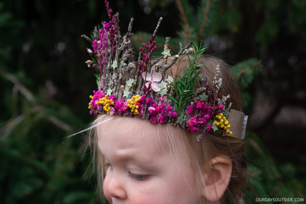 Close up of little girl wearing flower crown made of dried flowers and twigs. 