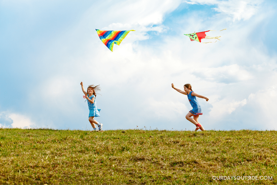 two girls on hill top flying kites - easter basket gift ideas for kids